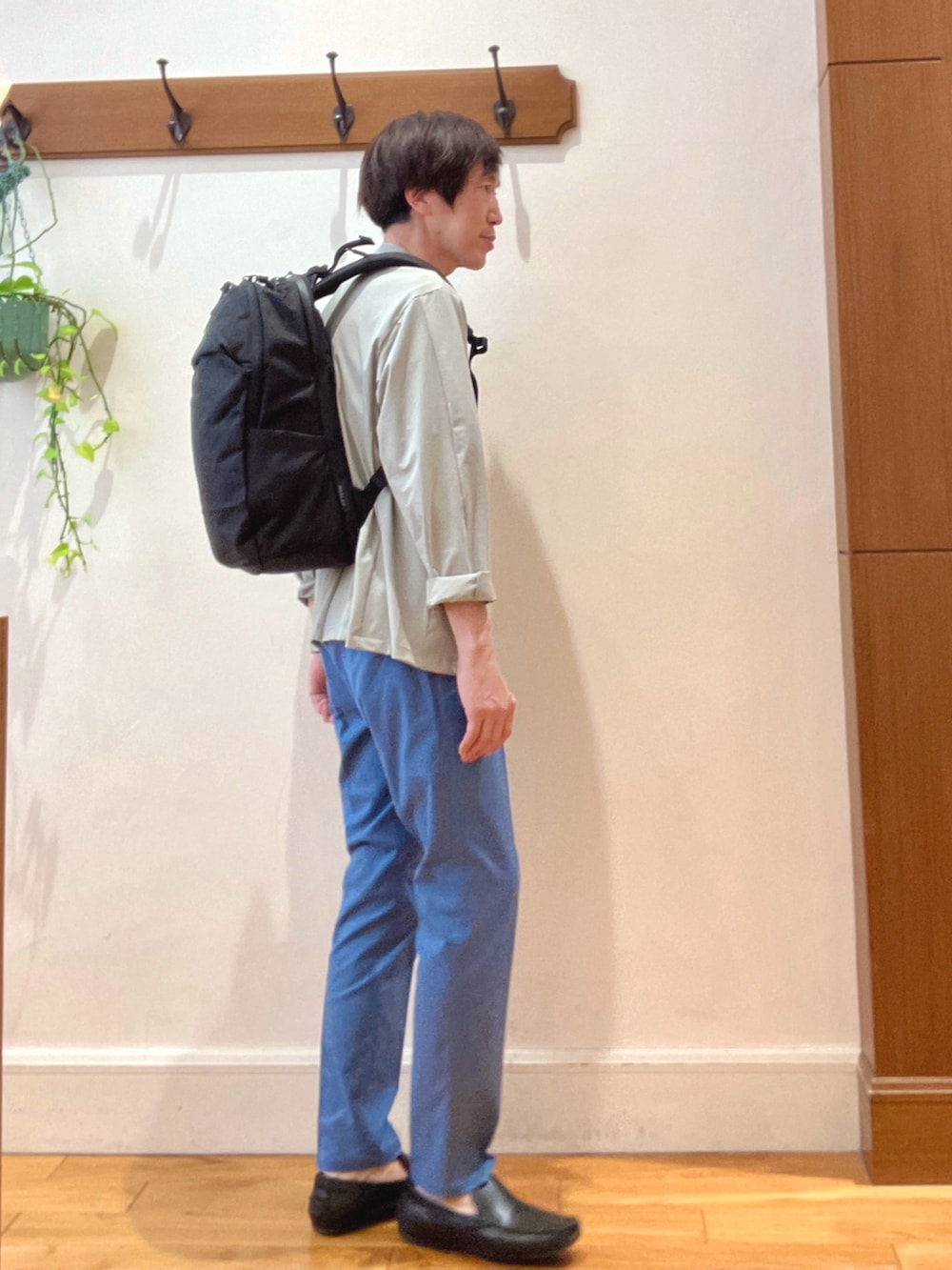 ブラック系のバックパック/リュック、ブルー系のチノパンツ、ブルー系のTシャツ/カットソーを着用したメンズの春コーディネートの5枚目の写真