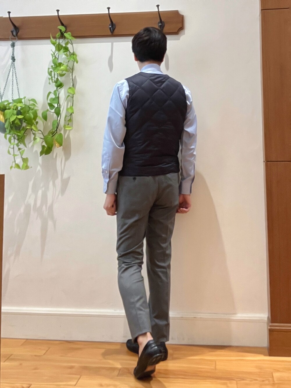 グレー系のその他パンツ、ブルー系のビジネスシャツ、ブルー系のダウンベストを着用したメンズの秋コーディネートの5枚目の写真