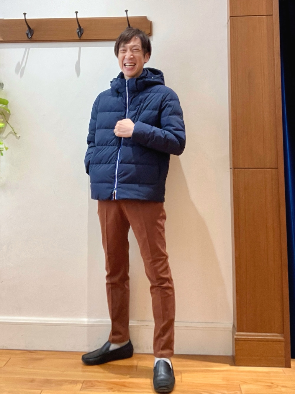 ブルー系のダウンジャケット/コート、イエロー系のチノパンツ、ブラック系のバックパック/リュックを着用したメンズの冬コーディネートの9枚目の写真