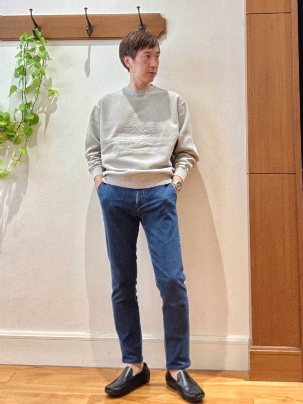 ベージュ系のスウェット、ブルー系のデニムパンツ、ブラック系のバックパック/リュックを着用したメンズの秋コーディネートの7枚目の写真