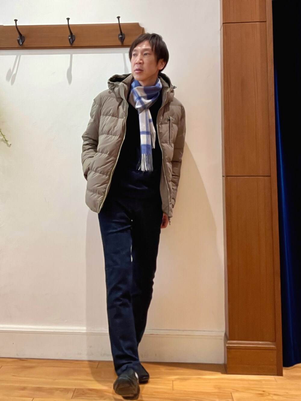 グリーン系のダウンジャケット/コート、ブルー系のニット/セーター、ブルー系のデニムパンツを着用したメンズの冬コーディネートの7枚目の写真