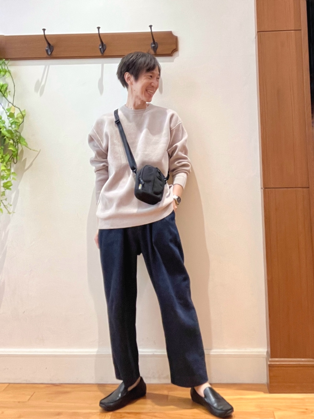 ブルー系のデニムパンツ、ブラック系のショルダーバッグ、ベージュ系のニット/セーターを着用したメンズの秋コーディネートの8枚目の写真