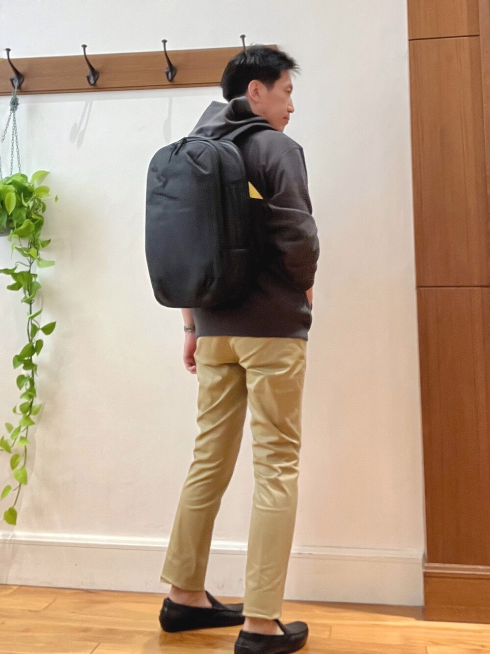 ベージュ系のその他パンツ、ブラック系のパーカー、ブラック系のバックパック/リュックを着用したメンズの秋コーディネートの6枚目の写真