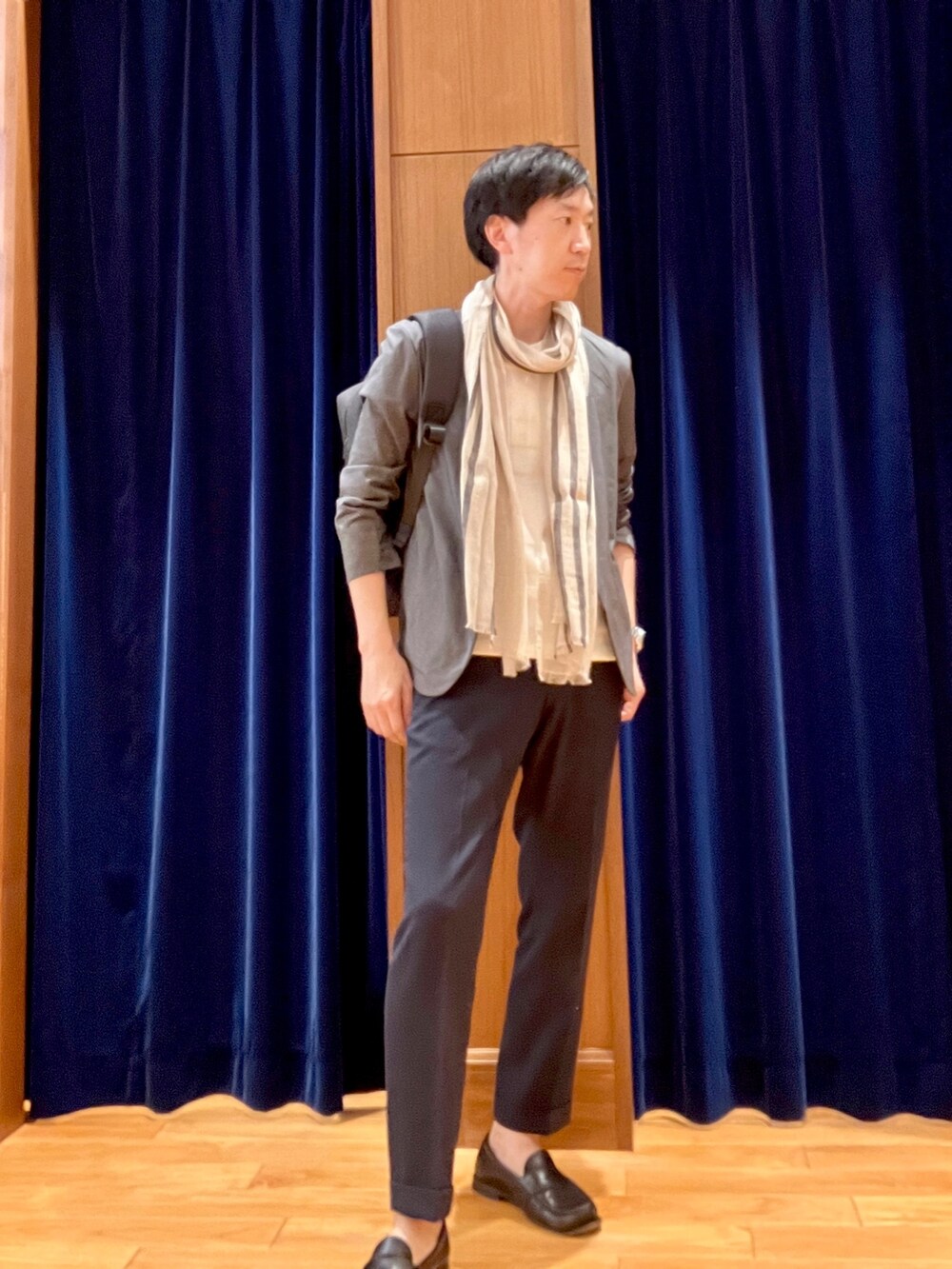 グレー系のノーカラージャケット、ホワイト系のTシャツ/カットソー、ブラック系のバックパック/リュックを着用したメンズの春コーディネートの2枚目の写真