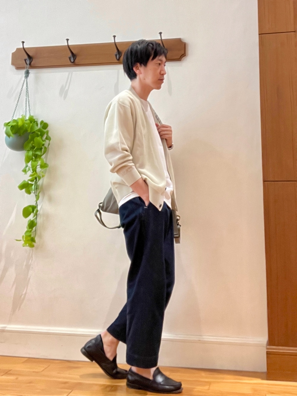 ベージュ系のカーディガン/ボレロ、グリーン系のトートバッグ、ホワイト系のTシャツ/カットソーを着用したメンズの春コーディネートの5枚目の写真