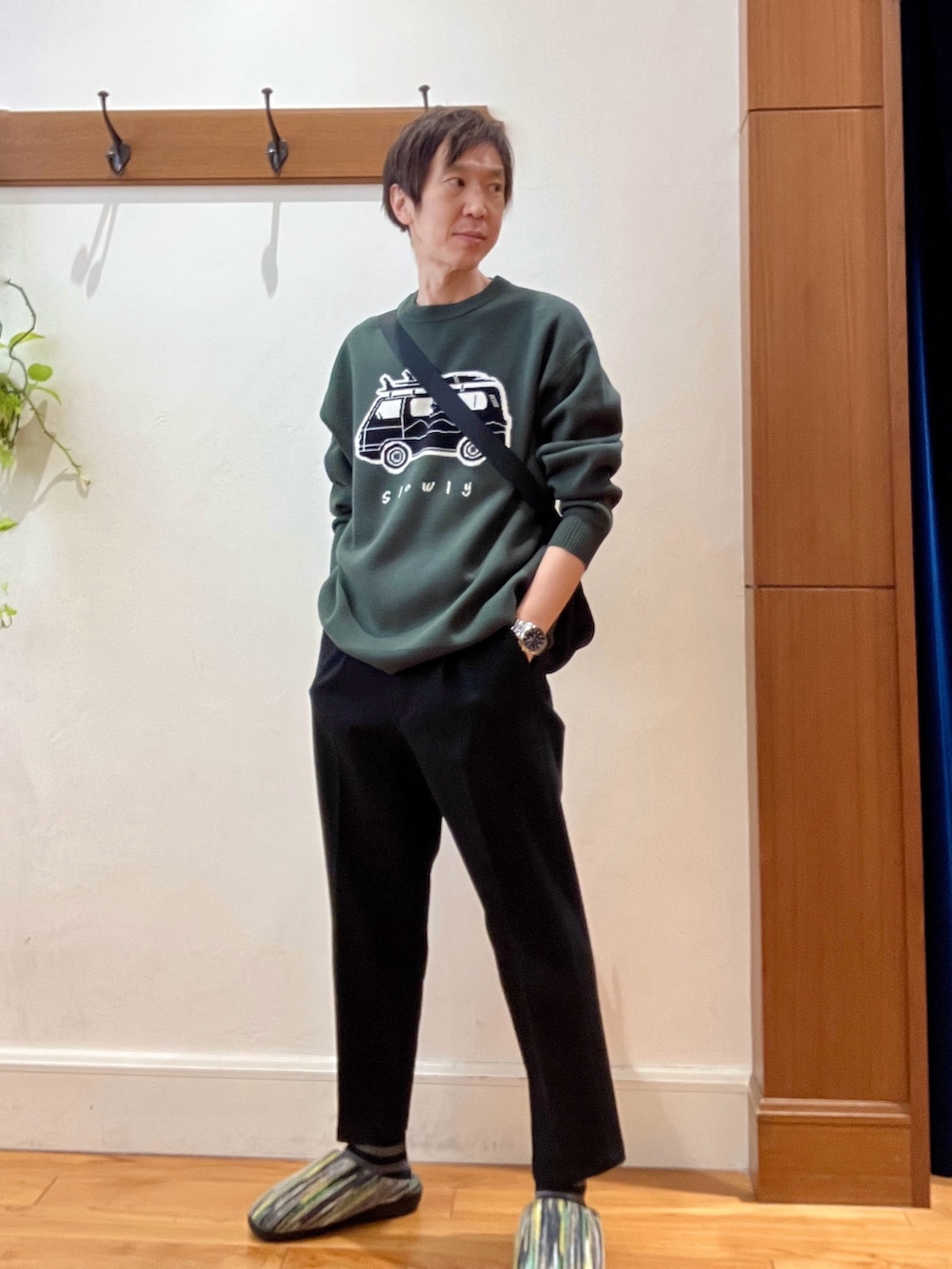 グリーン系のニット/セーター、ブラック系のショルダーバッグ、グリーン系のサンダルを着用したメンズの冬コーディネートの2枚目の写真