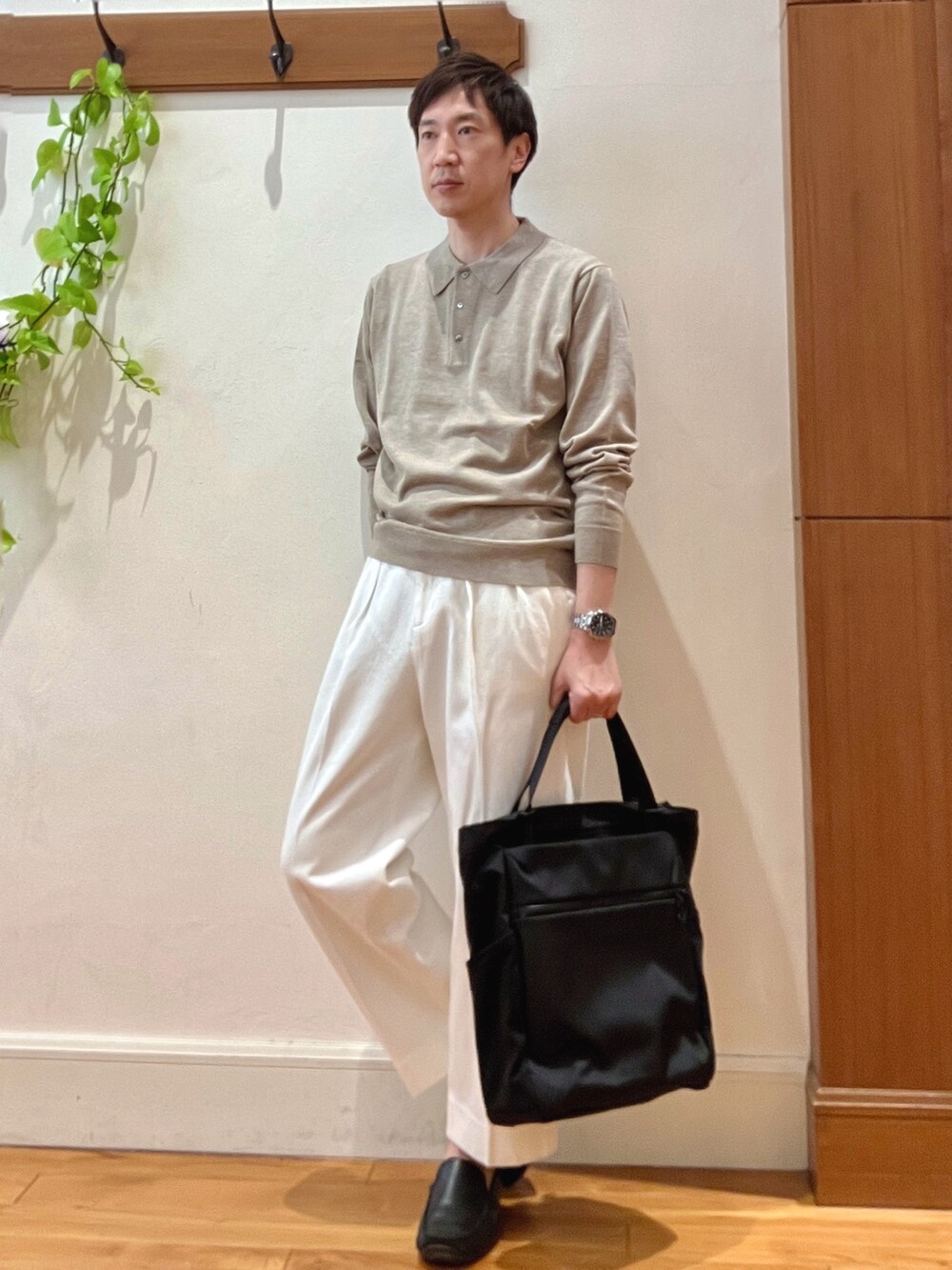 ホワイト系のデニムパンツ、ブラック系のトートバッグ、ベージュ系のニット/セーターを着用したメンズの冬コーディネートの3枚目の写真