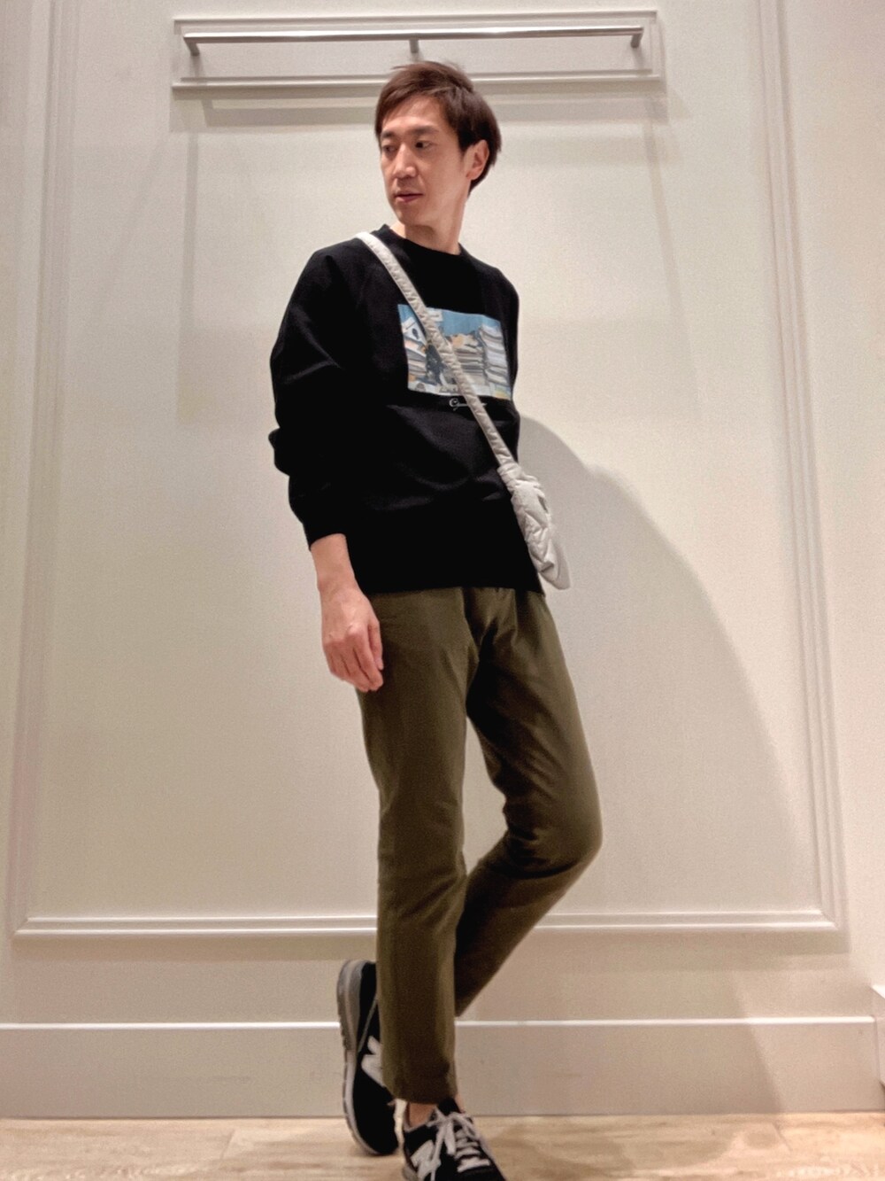 ブラック系のスウェット、グリーン系のショルダーバッグを着用したメンズの冬コーディネートの6枚目の写真