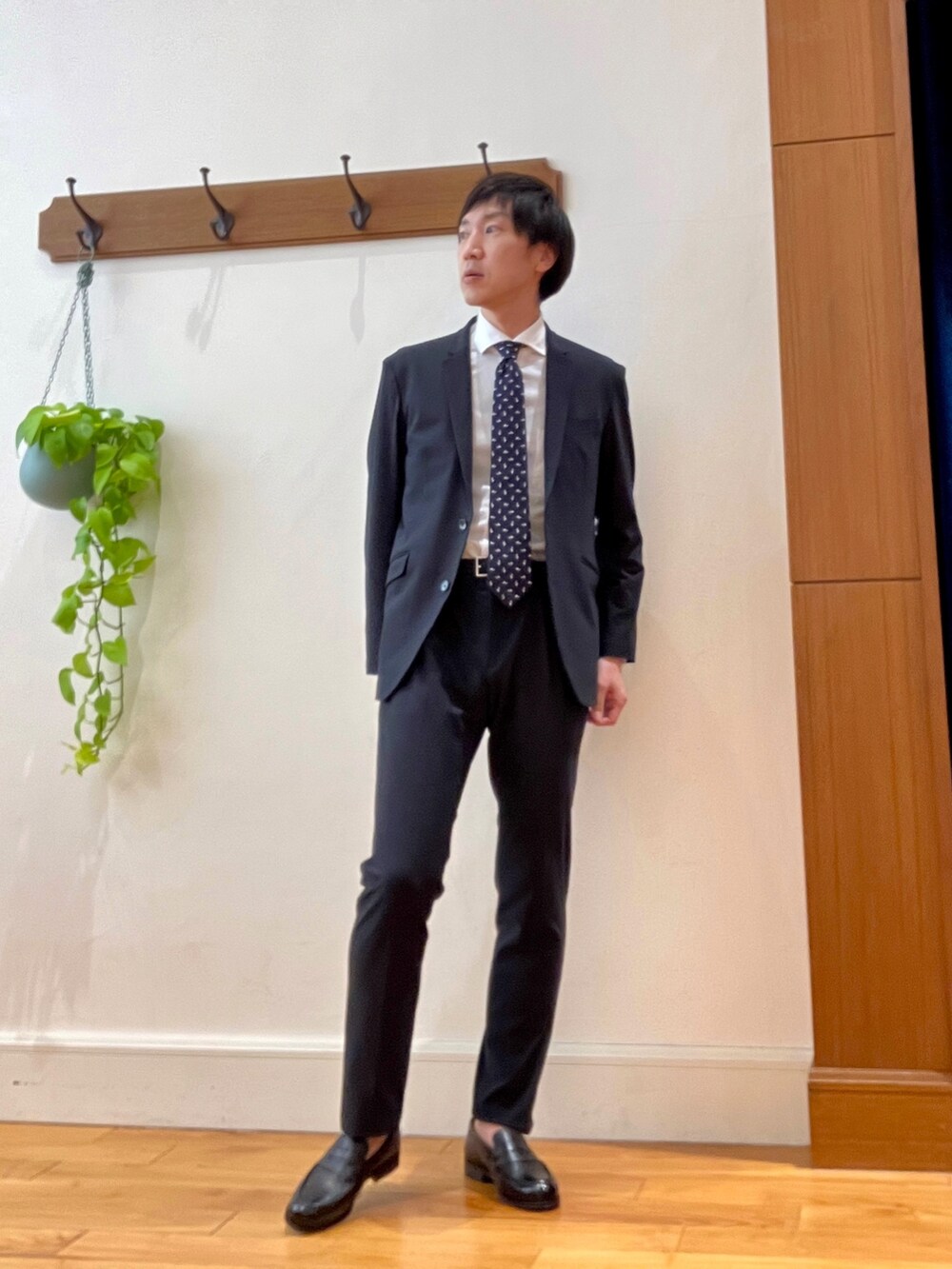 ブラック系のローファー、ブルー系のその他パンツ、ブルー系のネクタイを着用したメンズの冬コーディネートの2枚目の写真