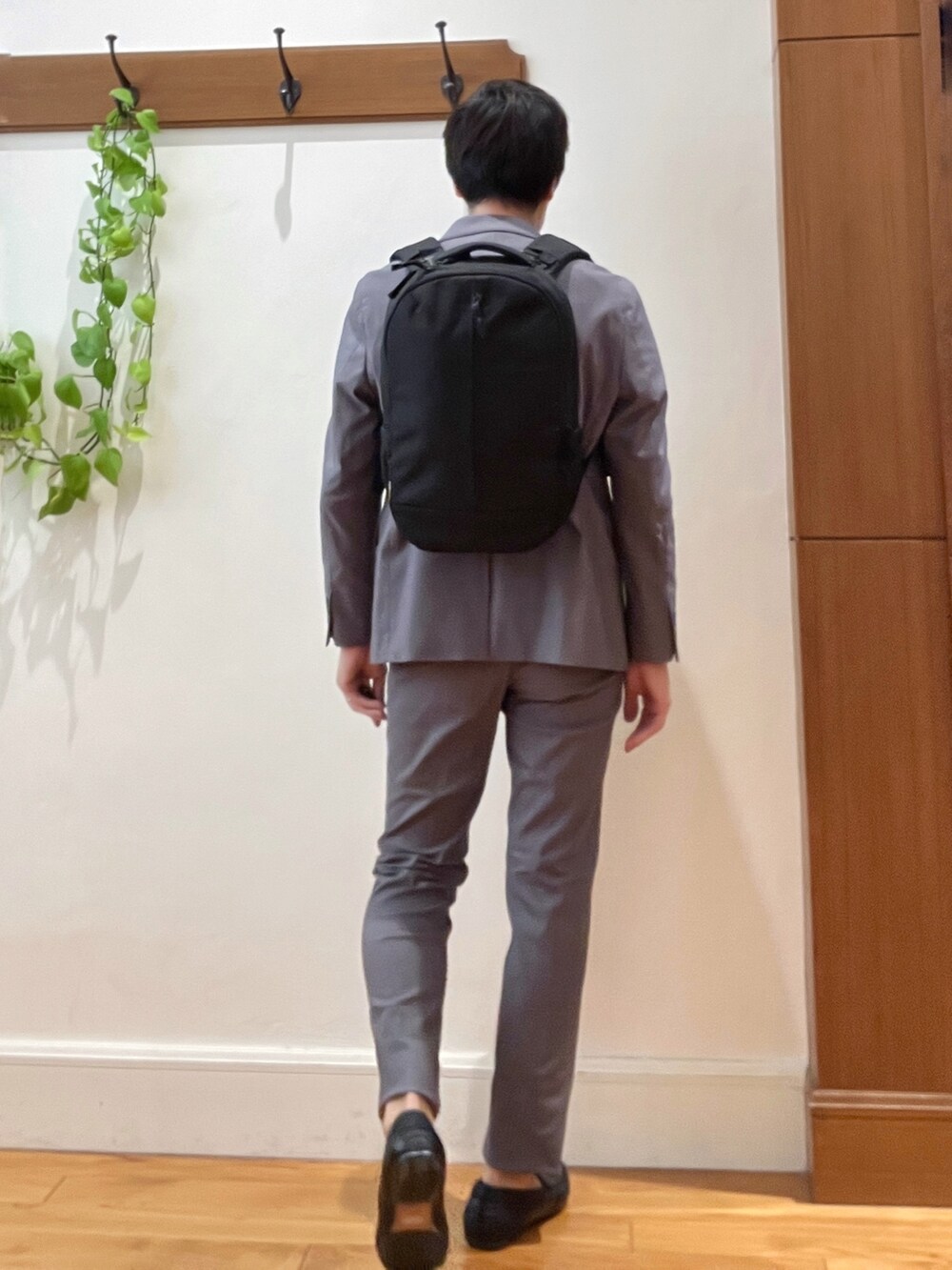 ブラック系のバックパック/リュック、ブラック系のTシャツ/カットソー、グレー系のテーラードジャケットを着用したメンズの秋コーディネートの5枚目の写真