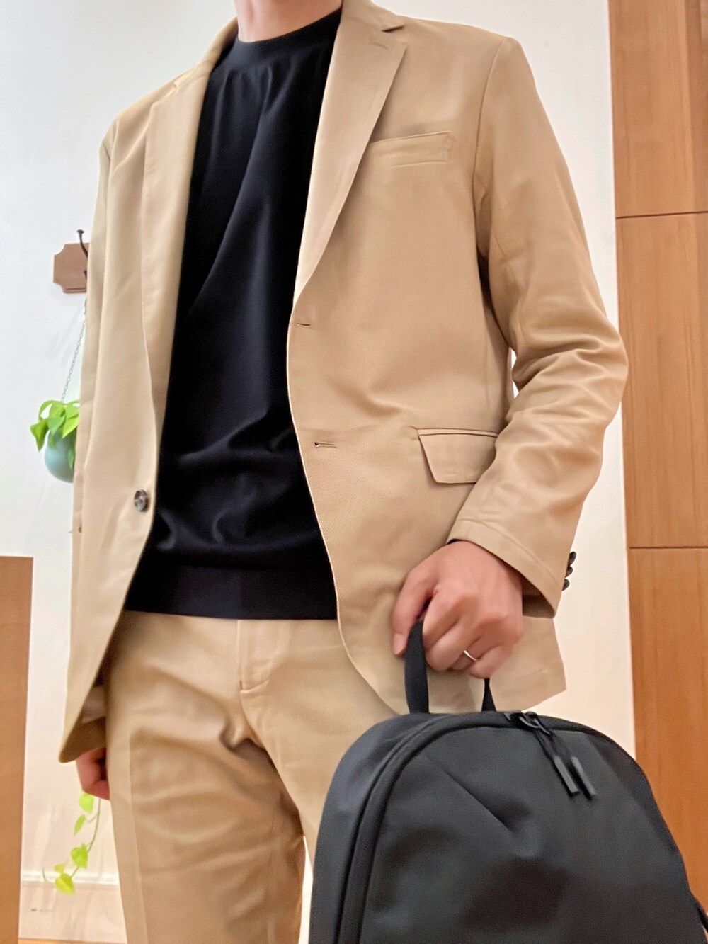 ベージュ系のテーラードジャケット、ブラック系のTシャツ/カットソー、ブラック系のバックパック/リュックを着用したメンズの秋コーディネートの7枚目の写真