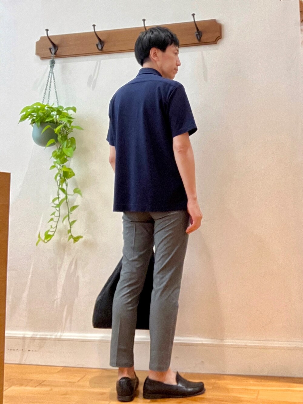 グレー系のその他パンツ、ブルー系のポロシャツ、ブラック系のトートバッグを着用したメンズの春コーディネートの4枚目の写真