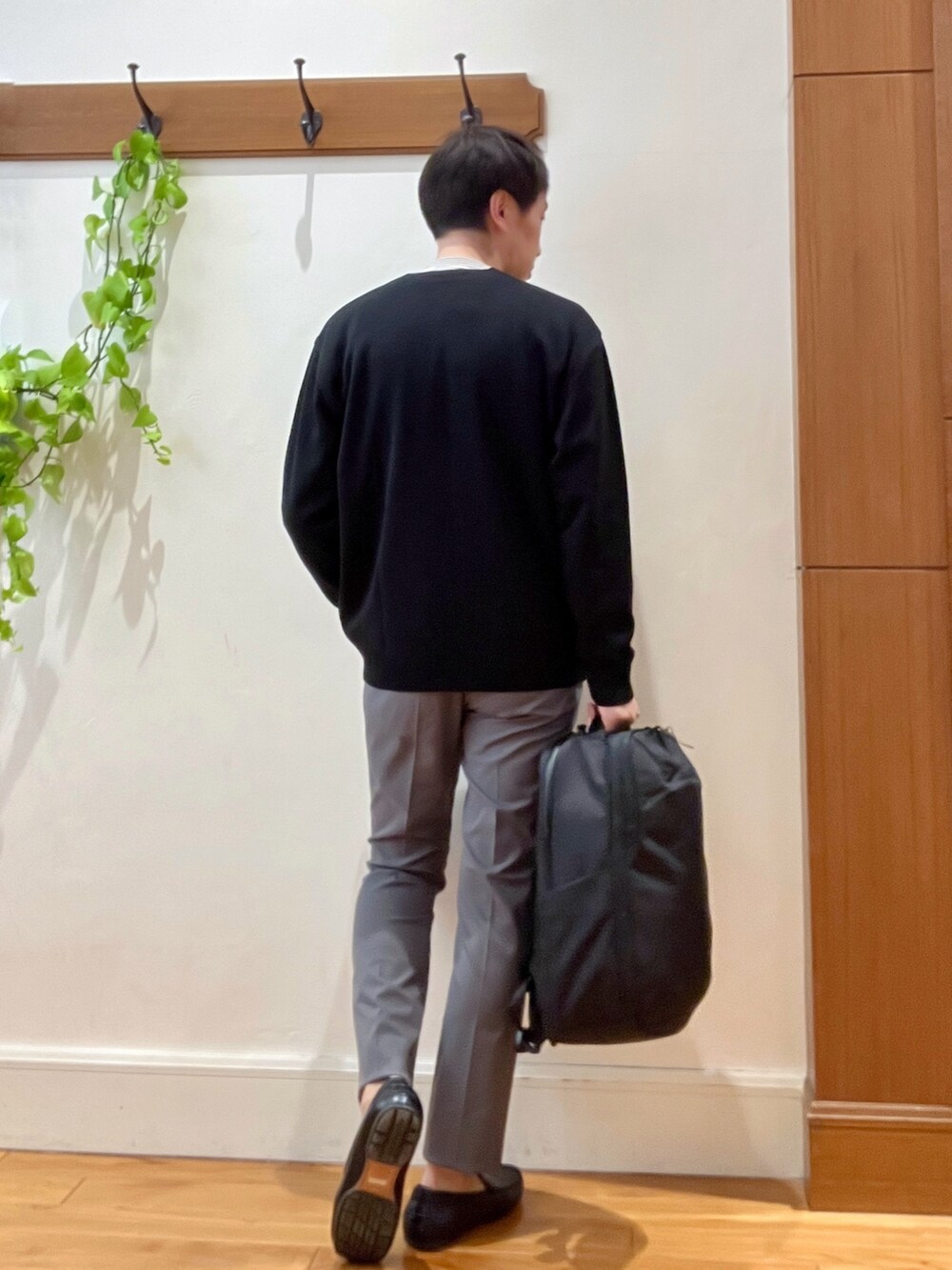 ブラック系のカーディガン/ボレロ、ホワイト系のTシャツ/カットソー、ブラック系のバックパック/リュックを着用したメンズの冬コーディネートの4枚目の写真