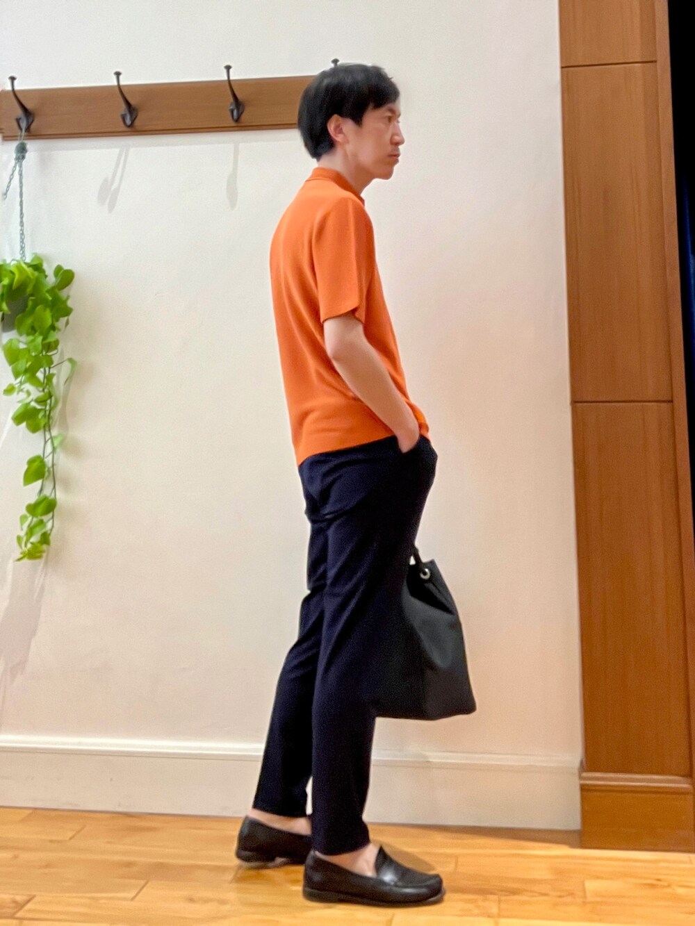 オレンジ系のポロシャツ、ブラック系のトートバッグ、ブルー系のその他パンツを着用したメンズの春コーディネートの6枚目の写真