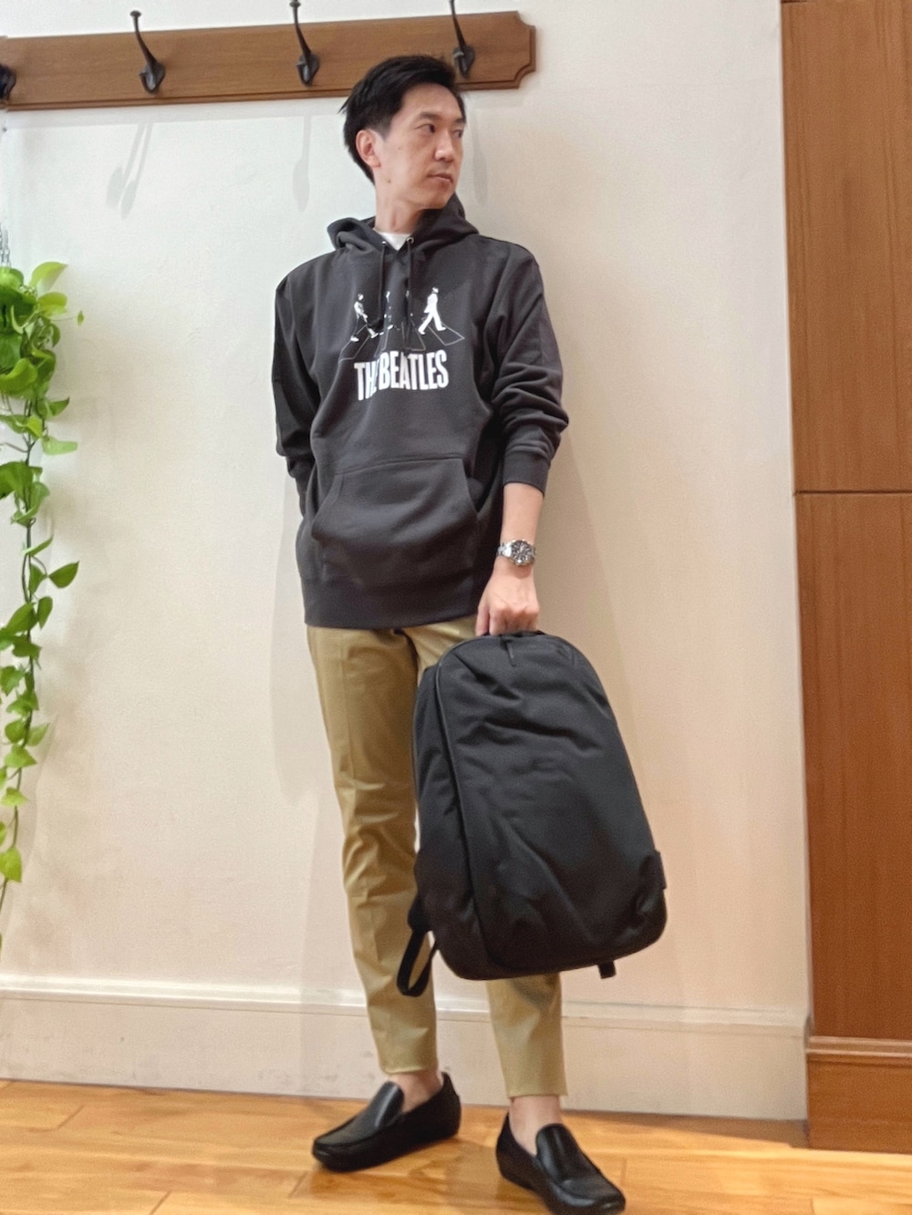 ベージュ系のその他パンツ、ブラック系のパーカー、ブラック系のバックパック/リュックを着用したメンズの秋コーディネートの2枚目の写真