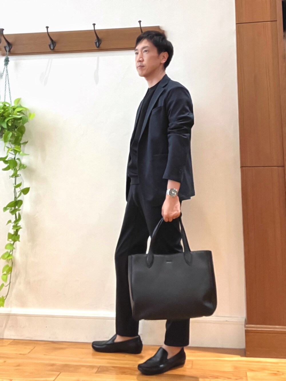 ブルー系のその他パンツ、ブラック系のトートバッグ、ブラック系のTシャツ/カットソーを着用したメンズの秋コーディネートの2枚目の写真