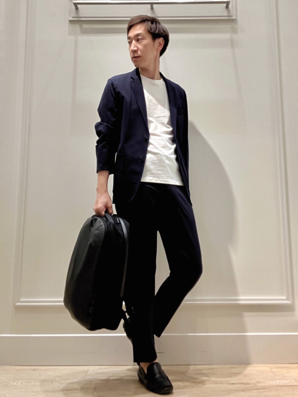 ブルー系のテーラードジャケット、ブラック系のバックパック/リュック、ブルー系のその他パンツを着用したメンズの冬コーディネートの7枚目の写真