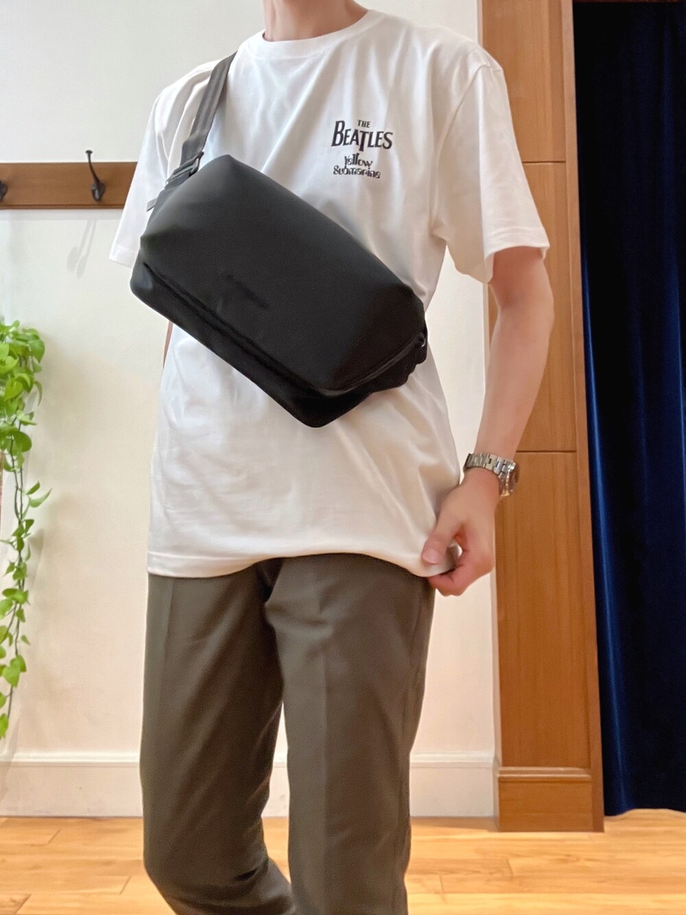 グリーン系のチノパンツ、ブラック系のショルダーバッグ、ホワイト系のTシャツ/カットソーを着用したメンズの春コーディネートの6枚目の写真