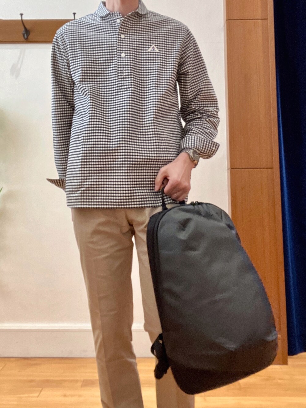 ブラック系のシャツ/ブラウス、グレー系のバックパック/リュック、ベージュ系のチノパンツを着用したメンズの春コーディネートの9枚目の写真