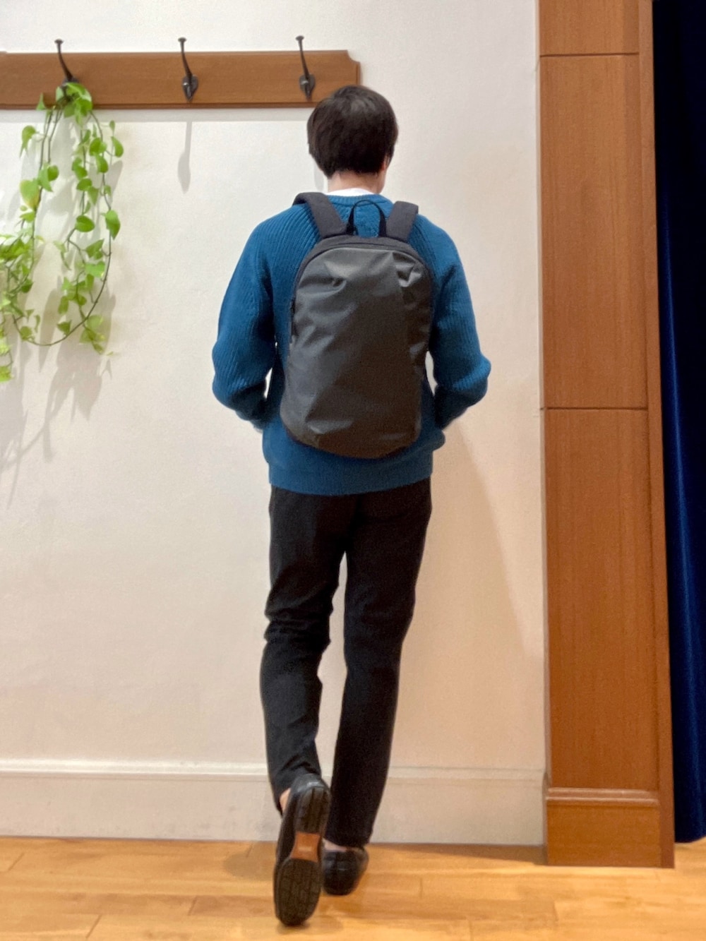 ブルー系のニット/セーター、グレー系のその他パンツ、グレー系のバックパック/リュックを着用したメンズの秋コーディネートの6枚目の写真