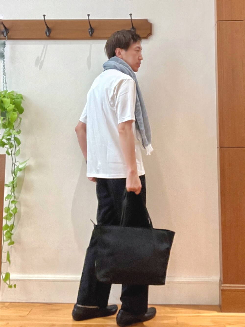 ブラック系のトートバッグ、ブラック系のその他パンツ、ホワイト系のTシャツ/カットソーを着用したメンズの春コーディネートの7枚目の写真