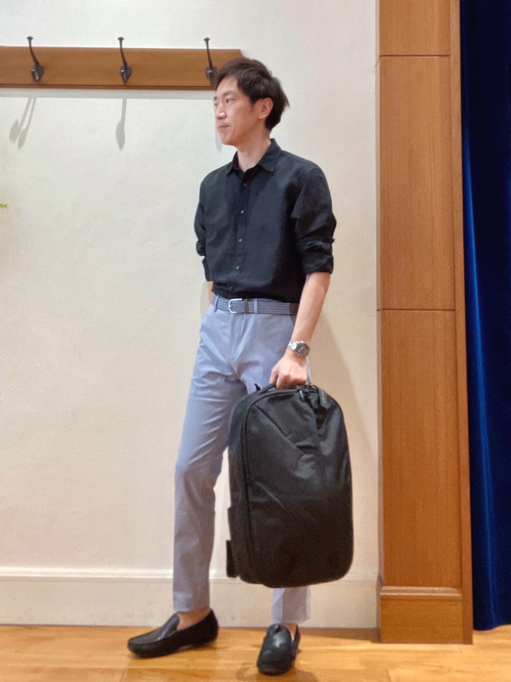 ブラック系のシャツ/ブラウス、ブルー系のチノパンツ、ブラック系のバックパック/リュックを着用したメンズの春コーディネートの2枚目の写真