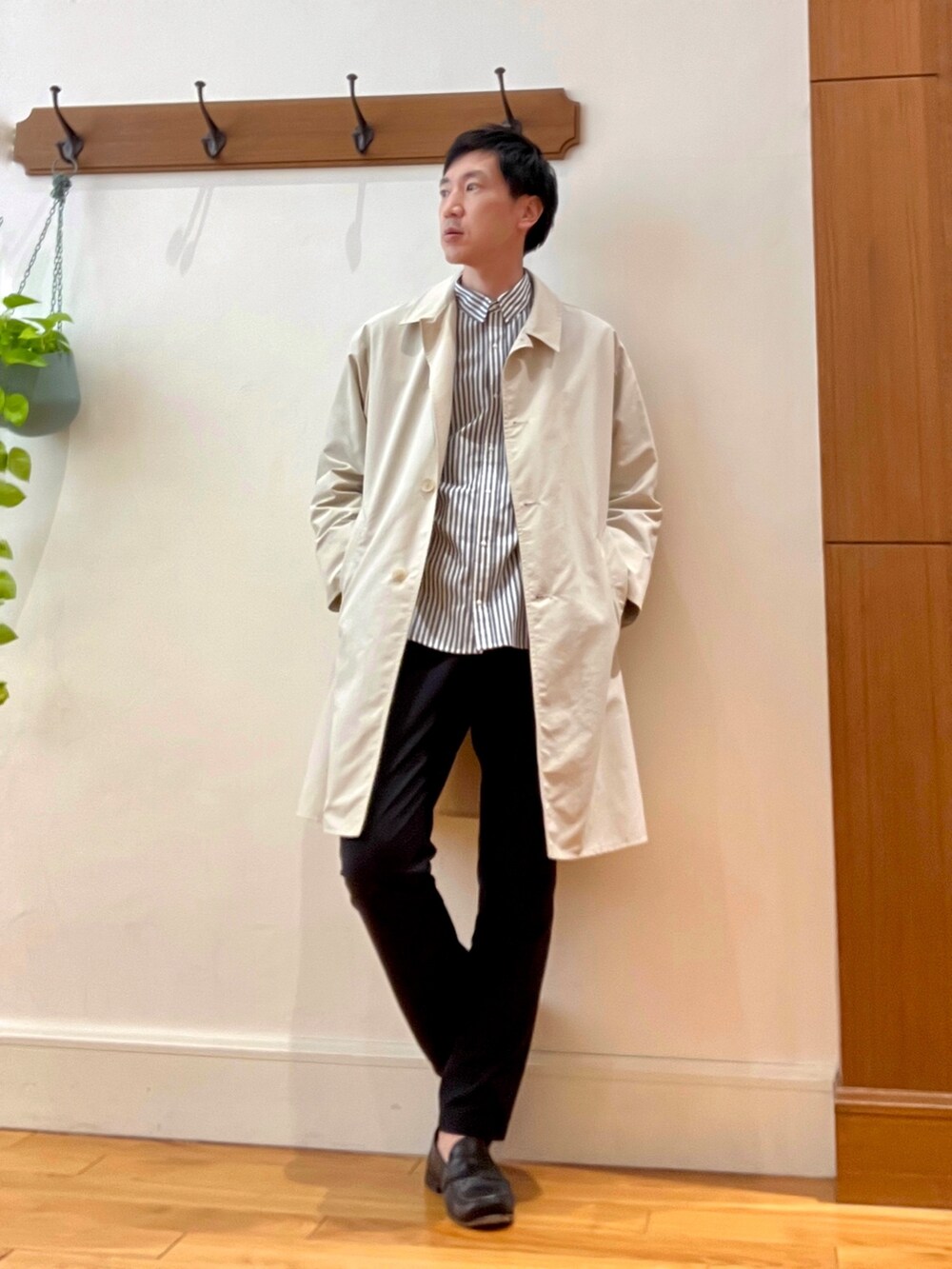 ホワイト系のステンカラーコート、グレー系のシャツ/ブラウス、レッド系のトートバッグを着用したメンズの春コーディネートの3枚目の写真