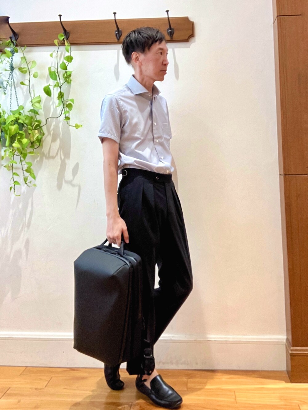 ブラック系のスラックス、ブルー系のビジネスシャツ、ブラック系のバックパック/リュックを着用したメンズの夏コーディネートの5枚目の写真