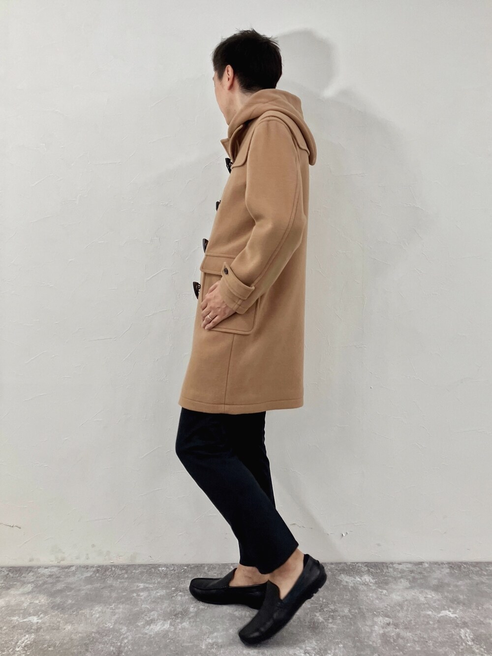 ブラック系のダッフルコートを着用したメンズの冬コーディネートの3枚目の写真