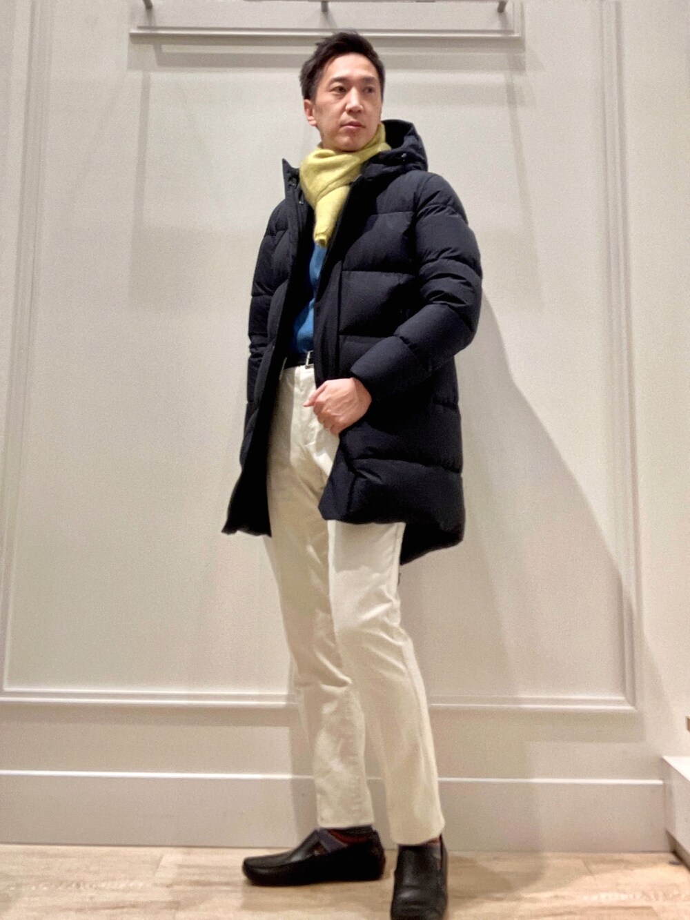 ブルー系のシャツ/ブラウス、ホワイト系のチノパンツ、ブラック系のダウンジャケット/コートを着用したメンズの秋コーディネートの2枚目の写真