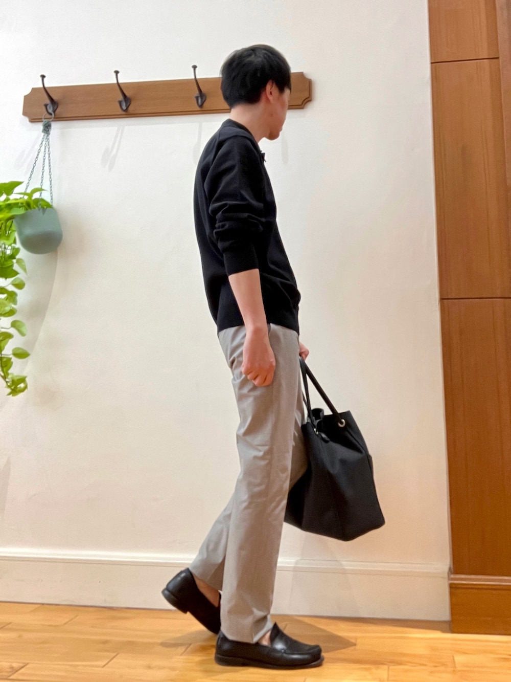 ブラック系のニット/セーター、ベージュ系のその他パンツ、ブラック系のトートバッグを着用したメンズの春コーディネートの7枚目の写真