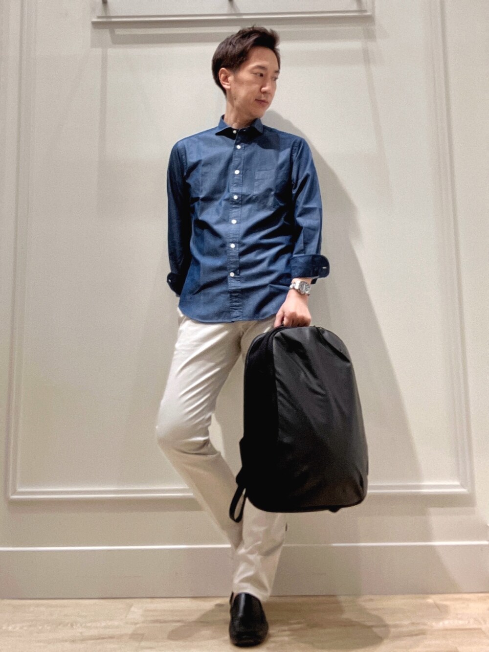 ブラック系のバックパック/リュック、グレー系のチノパンツ、ブルー系のシャツ/ブラウスを着用したメンズの冬コーディネートの7枚目の写真