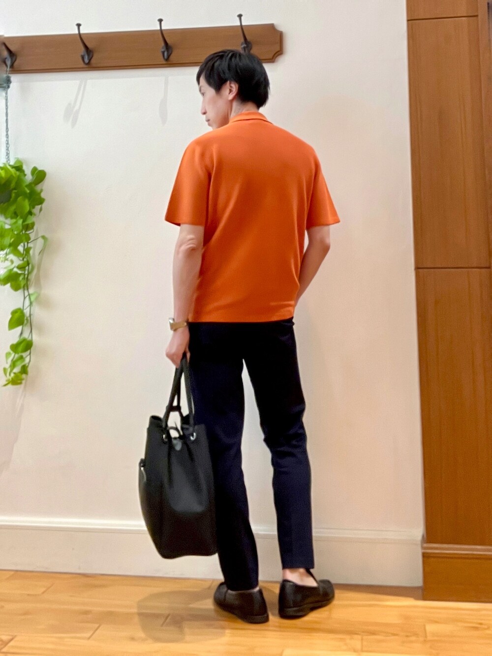 オレンジ系のポロシャツ、ブラック系のトートバッグ、ブルー系のその他パンツを着用したメンズの春コーディネートの7枚目の写真