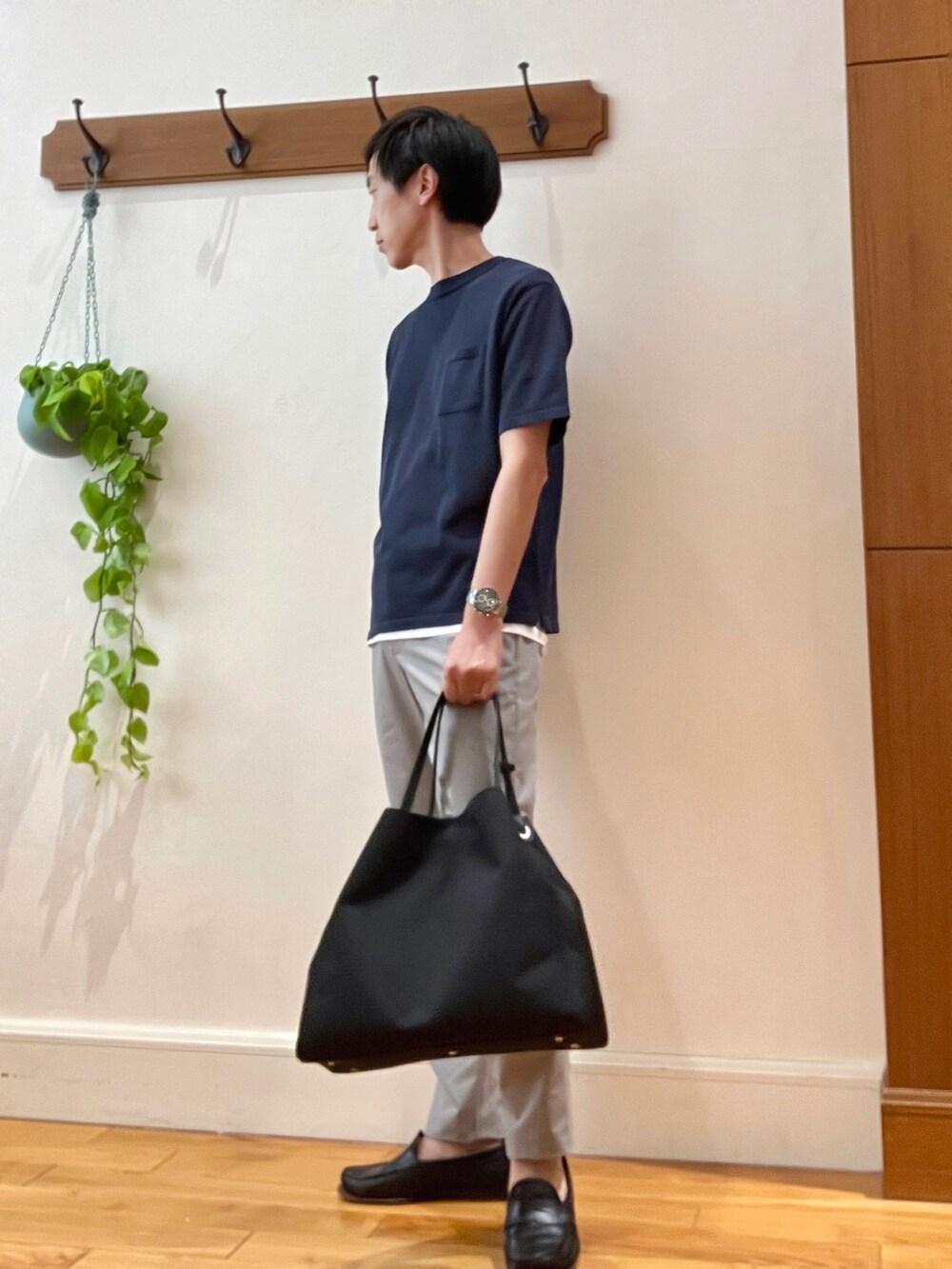 ベージュ系のその他パンツ、ブラック系のトートバッグ、グレー系のニット/セーターを着用したメンズの春コーディネートの3枚目の写真