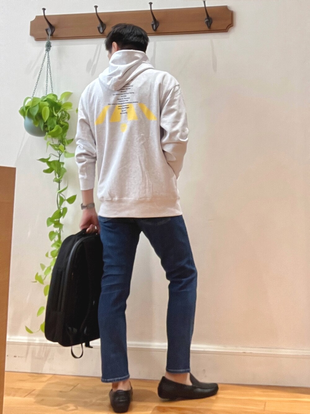 グレー系のパーカー、ブルー系のデニムパンツ、ブラック系のバックパック/リュックを着用したメンズの秋コーディネートの5枚目の写真