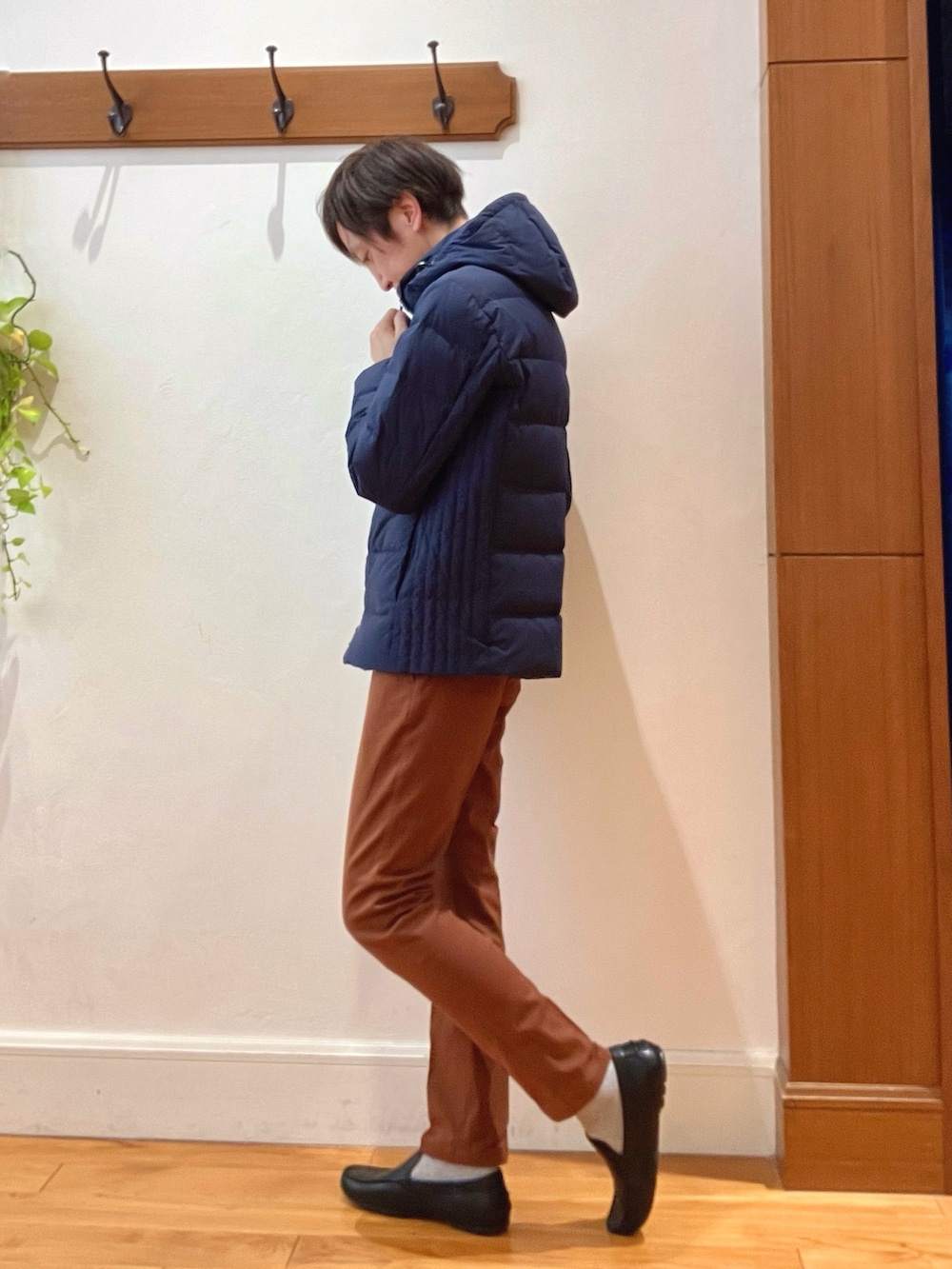 ブルー系のダウンジャケット/コート、イエロー系のチノパンツ、ブラック系のバックパック/リュックを着用したメンズの冬コーディネートの3枚目の写真