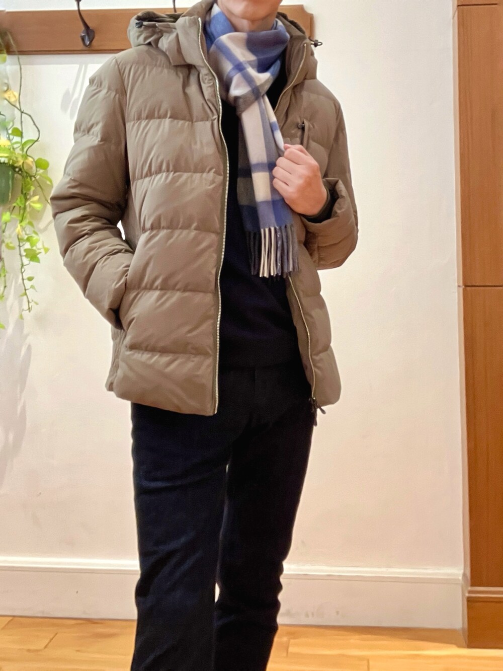 グリーン系のダウンジャケット/コート、ブルー系のニット/セーター、ブルー系のデニムパンツを着用したメンズの冬コーディネートの9枚目の写真