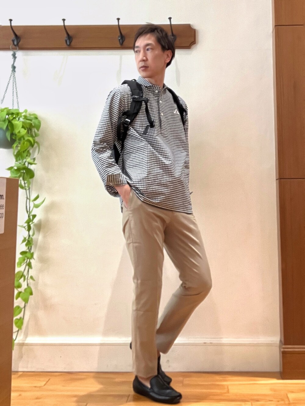 ブラック系のシャツ/ブラウス、グレー系のバックパック/リュック、ベージュ系のチノパンツを着用したメンズの春コーディネートの7枚目の写真