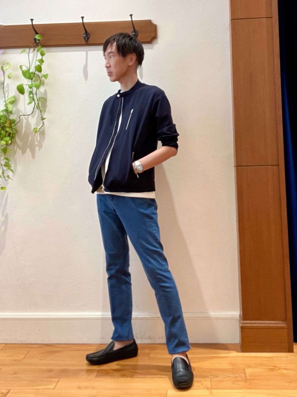 ブルー系のデニムパンツ、ベージュ系のトートバッグ、ホワイト系のTシャツ/カットソーを着用したメンズの秋コーディネートの3枚目の写真