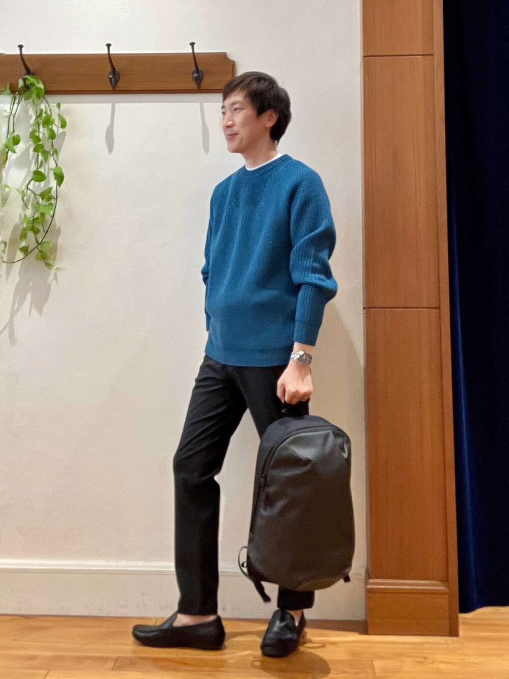 ブルー系のニット/セーター、グレー系のその他パンツ、グレー系のバックパック/リュックを着用したメンズの秋コーディネートの3枚目の写真