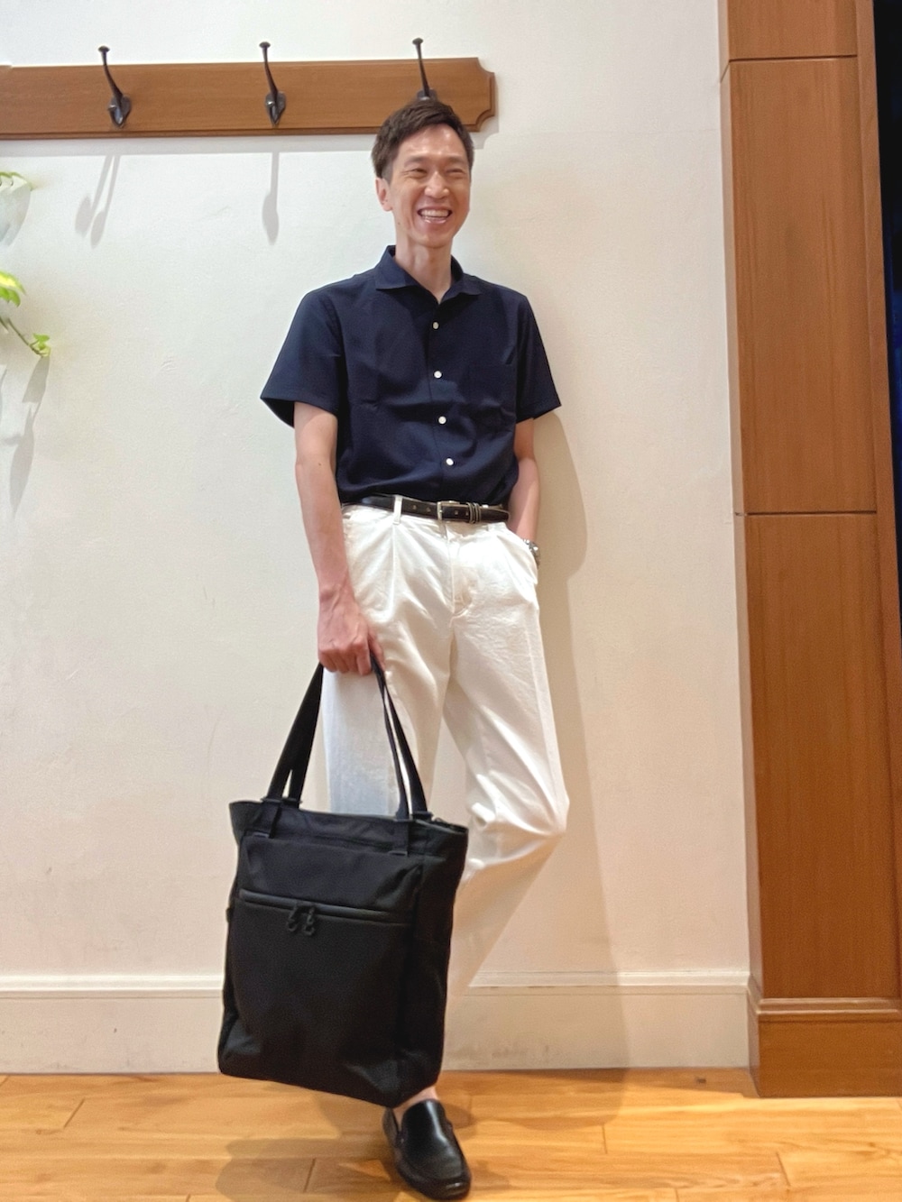 ホワイト系のデニムパンツ、ブルー系のビジネスシャツ、ブラック系のトートバッグを着用したメンズの夏コーディネートの6枚目の写真