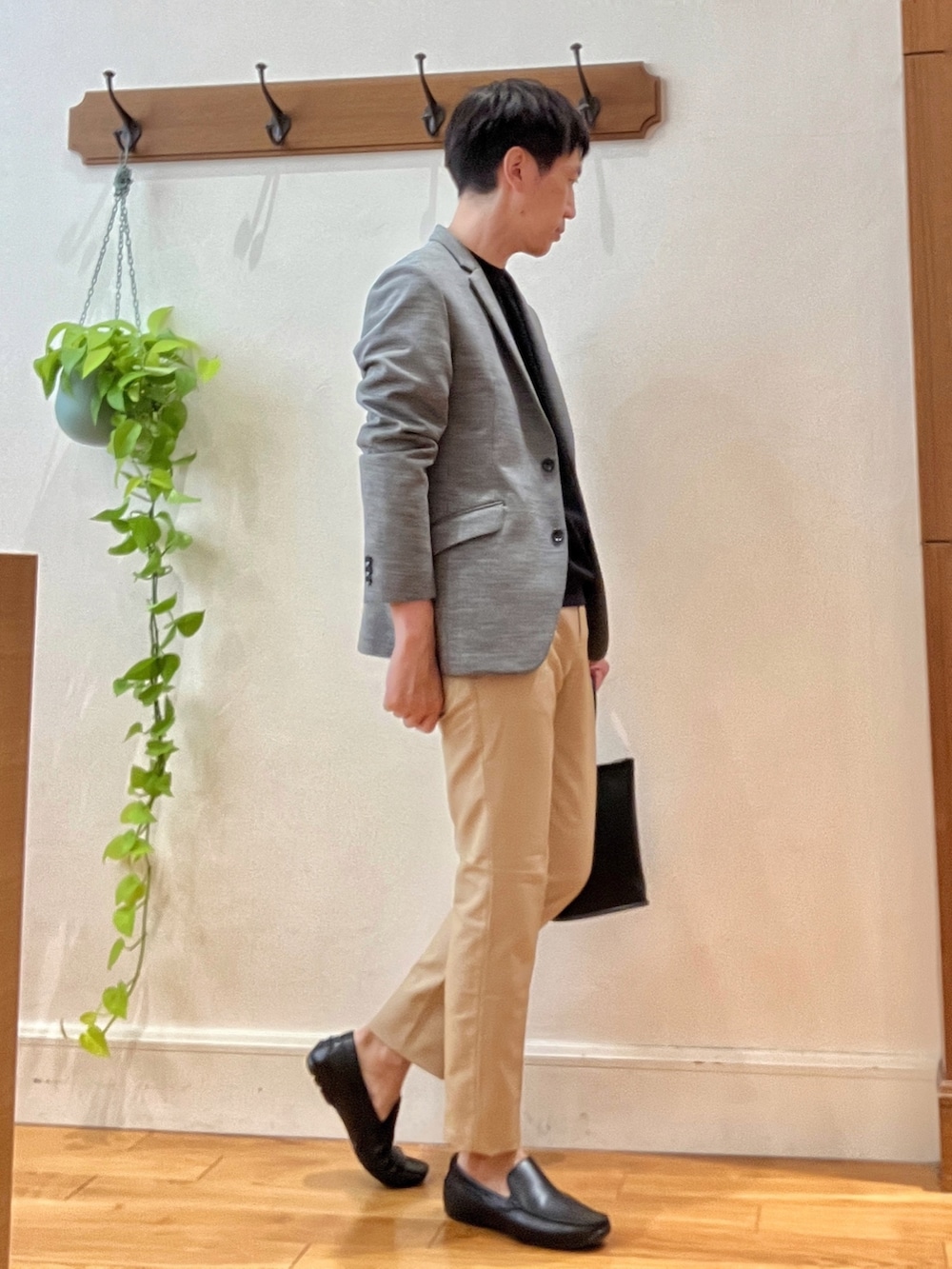 グレー系のテーラードジャケット、ブラック系のTシャツ/カットソー、ブラック系のハンドバッグを着用したメンズの秋コーディネートの6枚目の写真