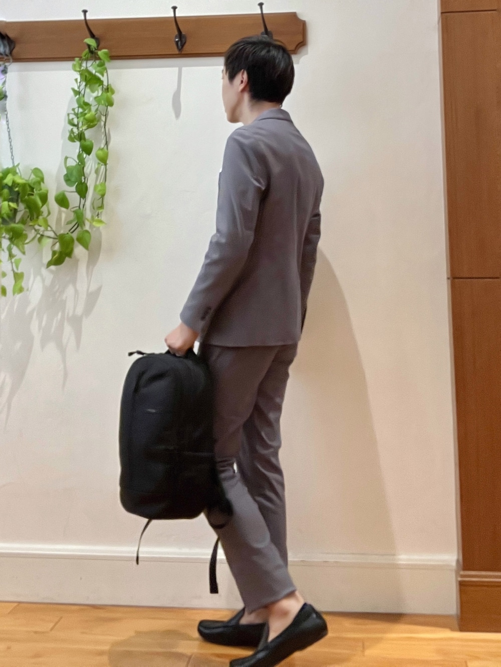 ブラック系のバックパック/リュック、ブラック系のTシャツ/カットソー、グレー系のテーラードジャケットを着用したメンズの秋コーディネートの4枚目の写真