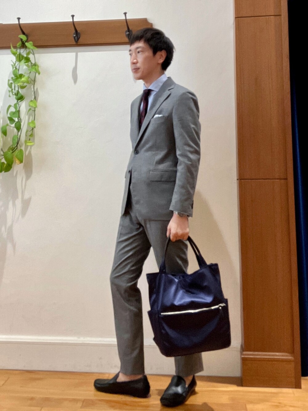 グレー系のその他パンツ、グレー系のテーラードジャケット、ブルー系のビジネスシャツを着用したメンズの秋コーディネートの3枚目の写真