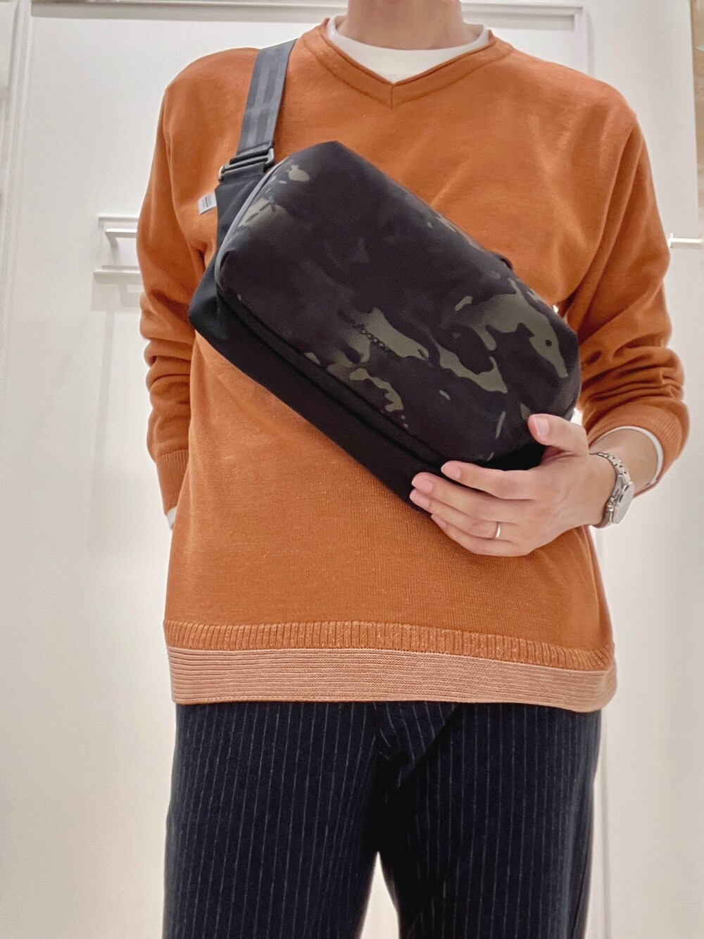 イエロー系のニット/セーター、ブラック系のショルダーバッグ、ブルー系のその他パンツを着用したメンズの秋コーディネートの6枚目の写真