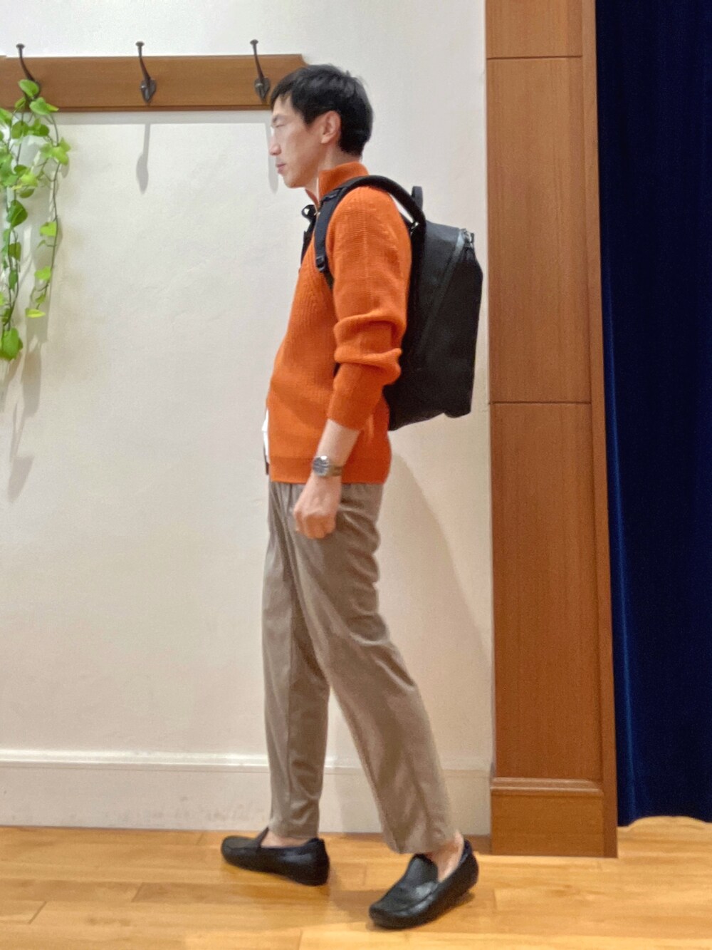 オレンジ系のニット/セーター、ブラック系のバックパック/リュック、ホワイト系のTシャツ/カットソーを着用したメンズの秋コーディネートの3枚目の写真