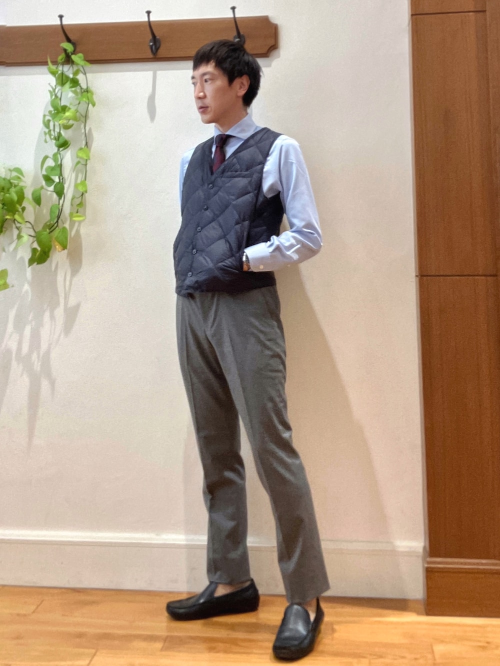 グレー系のその他パンツ、ブルー系のビジネスシャツ、ブルー系のダウンベストを着用したメンズの秋コーディネートの3枚目の写真