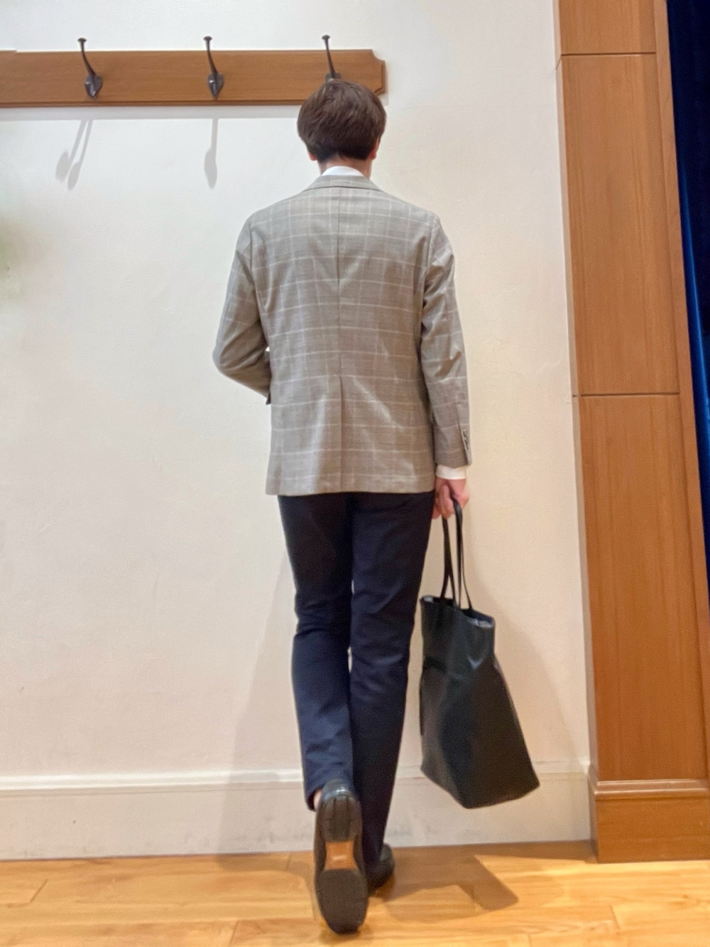 ブラック系のトートバッグ、ブルー系のチノパンツ、ブラウン系のテーラードジャケットを着用したメンズの夏コーディネートの5枚目の写真