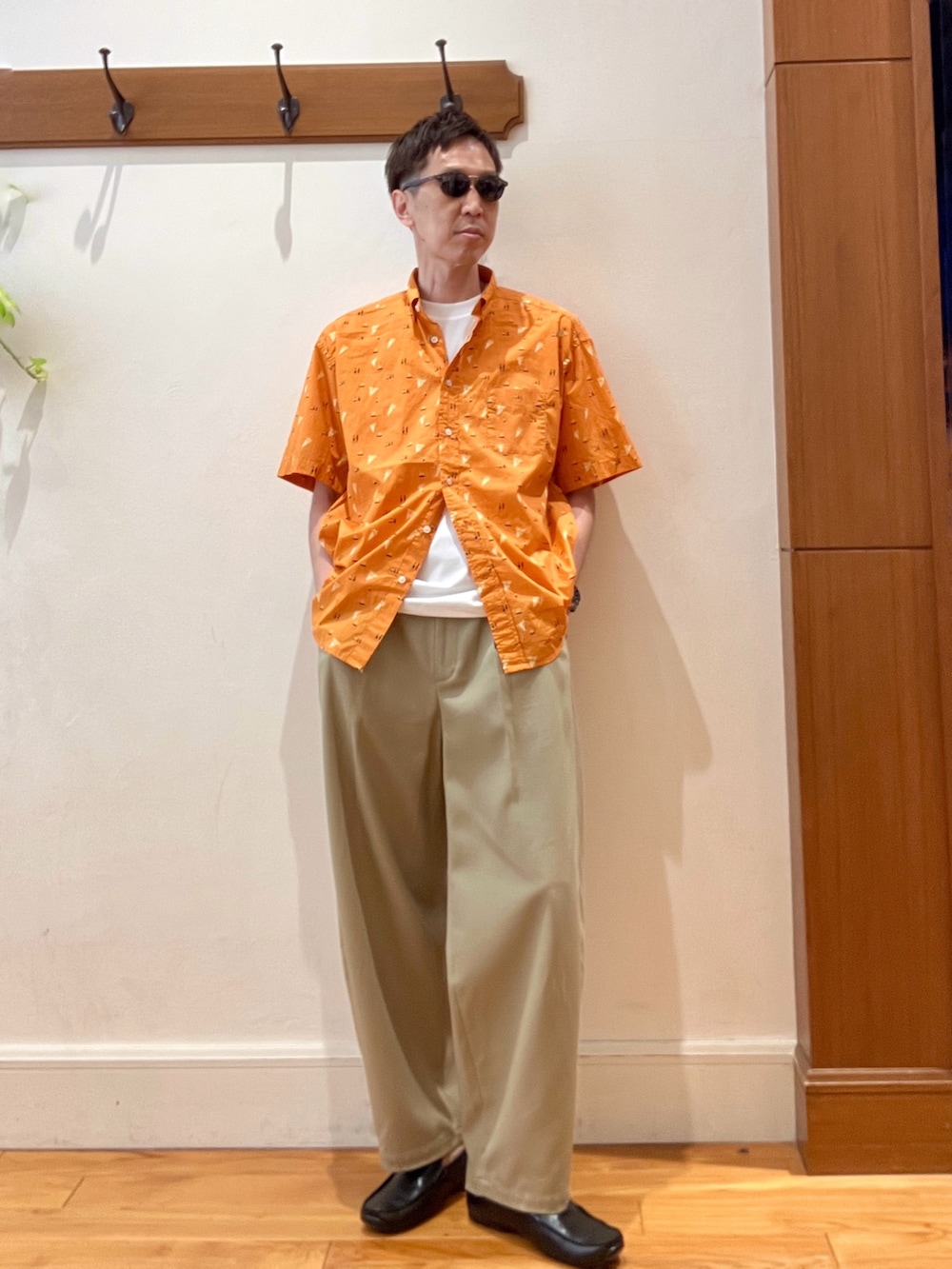 オレンジ系のシャツ/ブラウス、ホワイト系のTシャツ/カットソー、ブラウン系のサングラスを着用したメンズの夏コーディネートの8枚目の写真