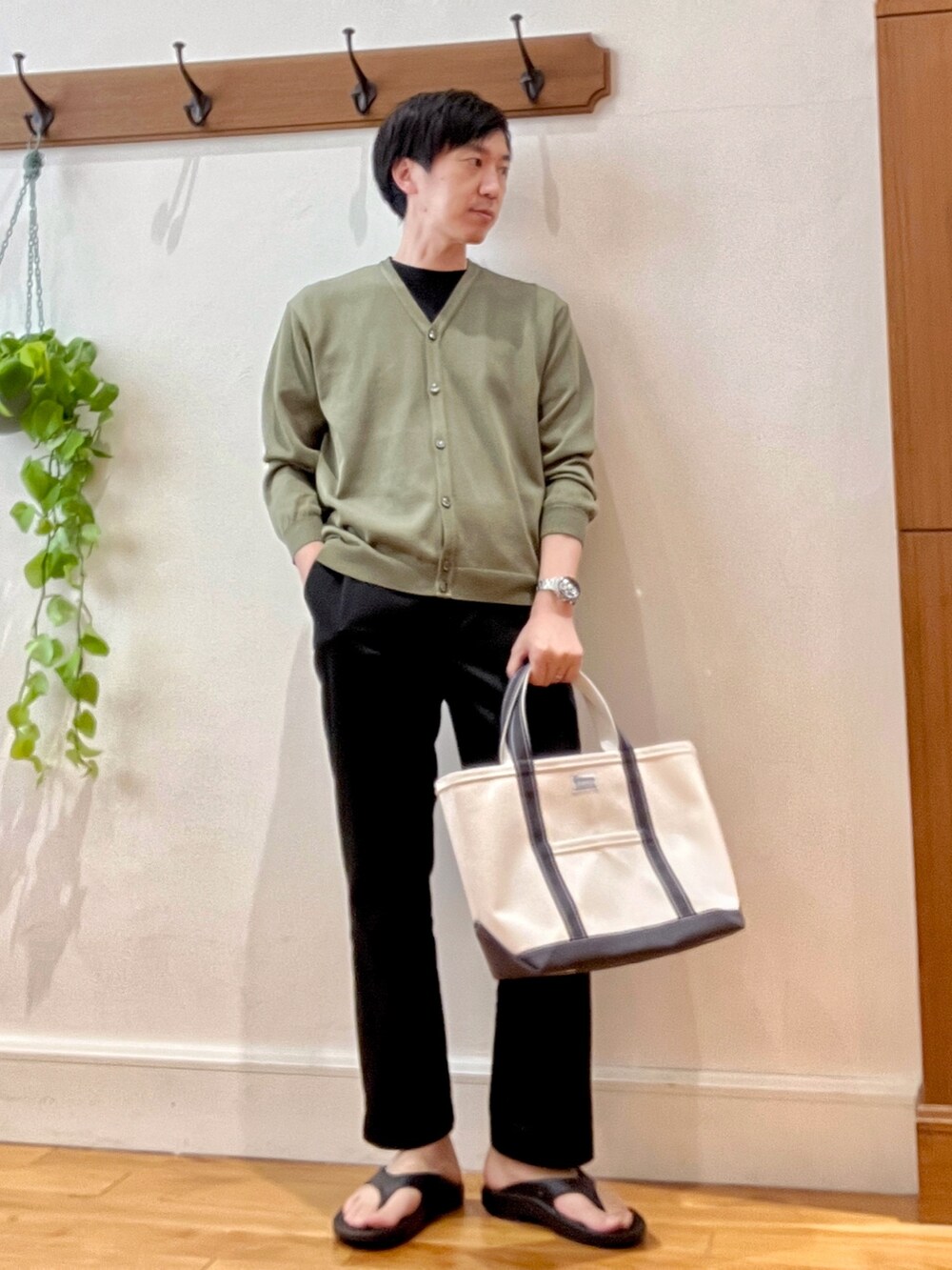グリーン系のカーディガン/ボレロ、ブラック系のサンダル、ホワイト系のトートバッグを着用したメンズの春コーディネートの7枚目の写真